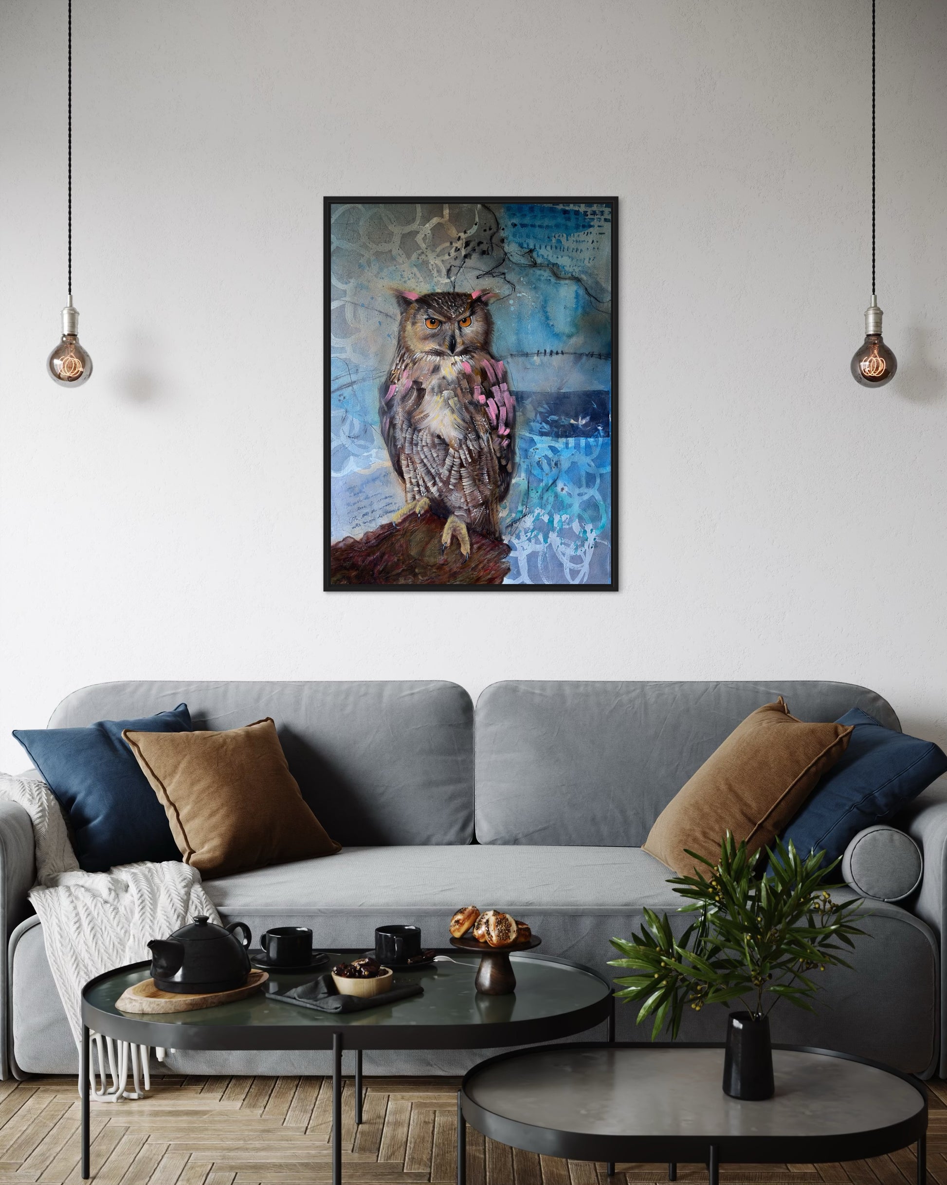 Living room with a gray sofa, decorative pillows, and a framed owl painting on the wall.