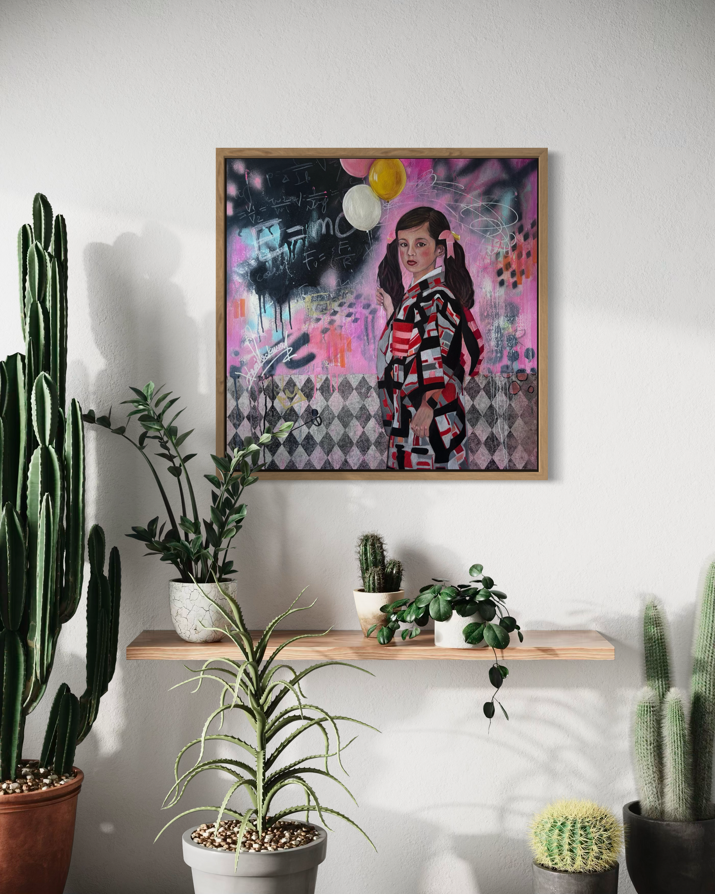 Framed abstract art on a wall with potted plants below