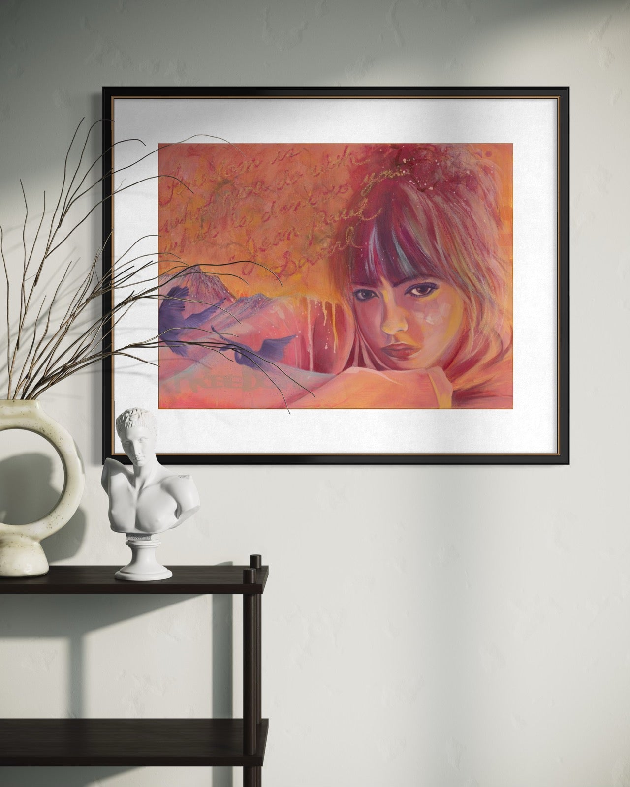 Framed artwork of a woman's face with abstract elements on a wall above a shelf.