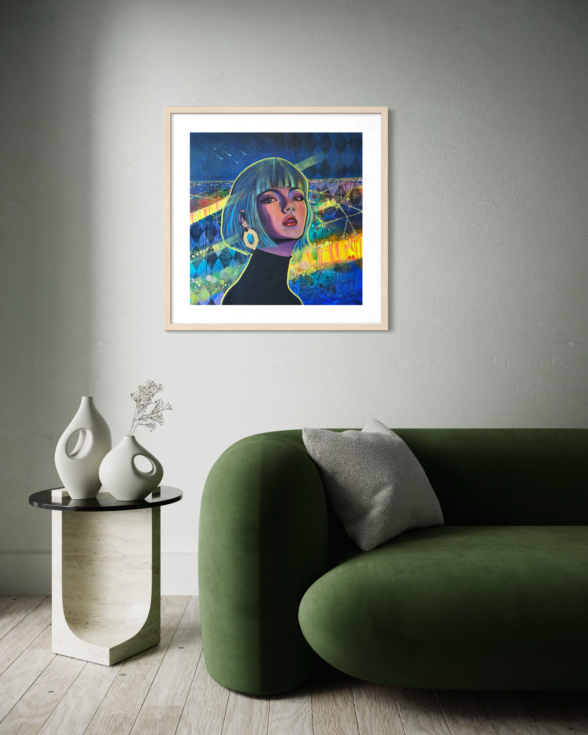 Framed artwork of a contemporary portrait painting inspired by Paris at night with vibrant blue, green and yellow tones, on a wall above a green sofa.