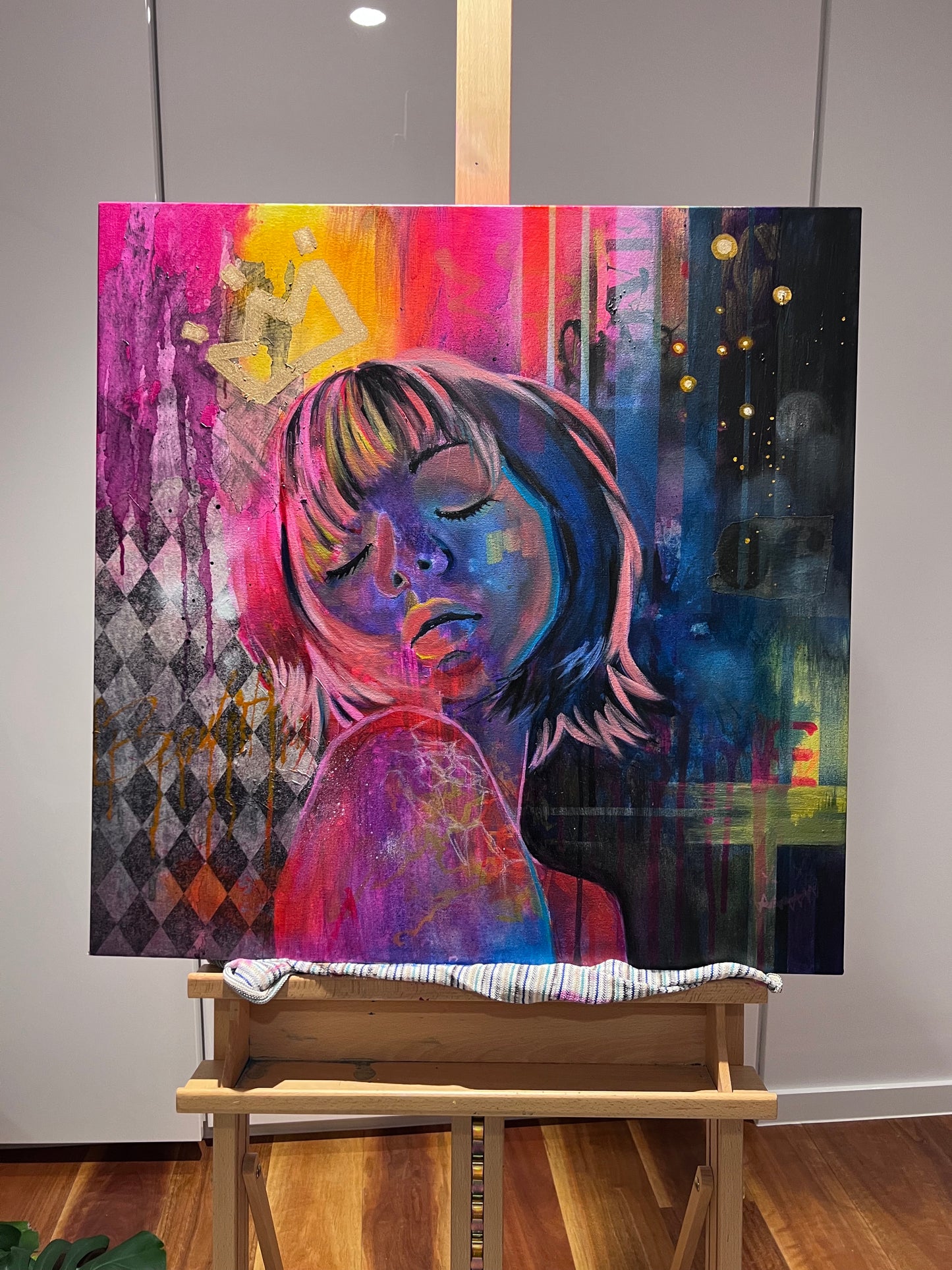 Contemporary portrait painting inspired by Tokyo nightlife with vibrant pink, blue and yellow tones and crown motif on an easel.