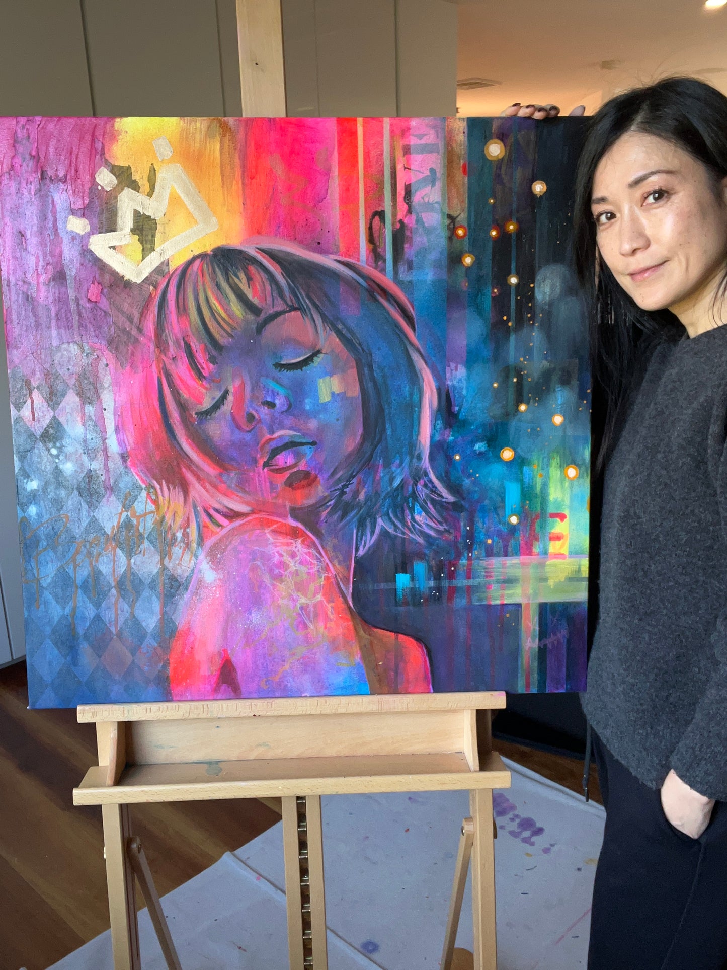 Artist with original contemporary portrait painting inspired by Tokyo nightlife with vibrant pink, blue and yellow tones and crown motif, statement wall art.